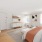 large, furnished bedroom with bright windows